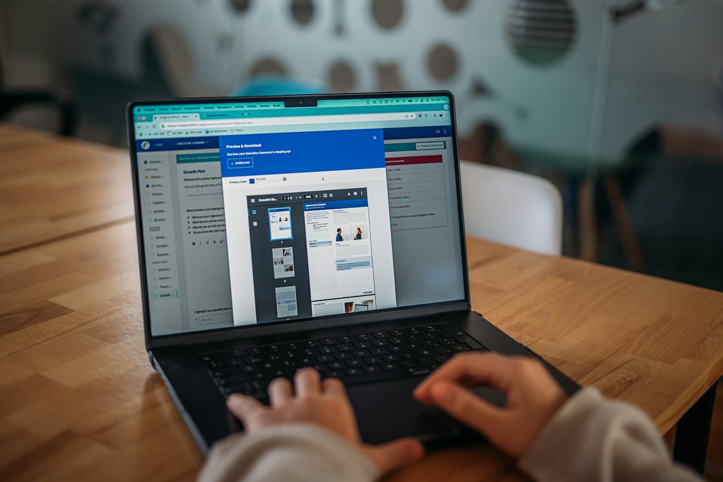 Hands typing on a laptop showing document preview.